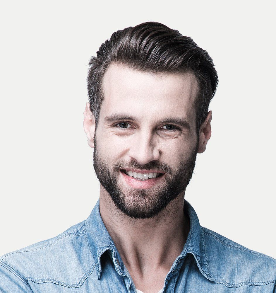 Man with a beard smiling, wearing a blue denim shirt against a white background.